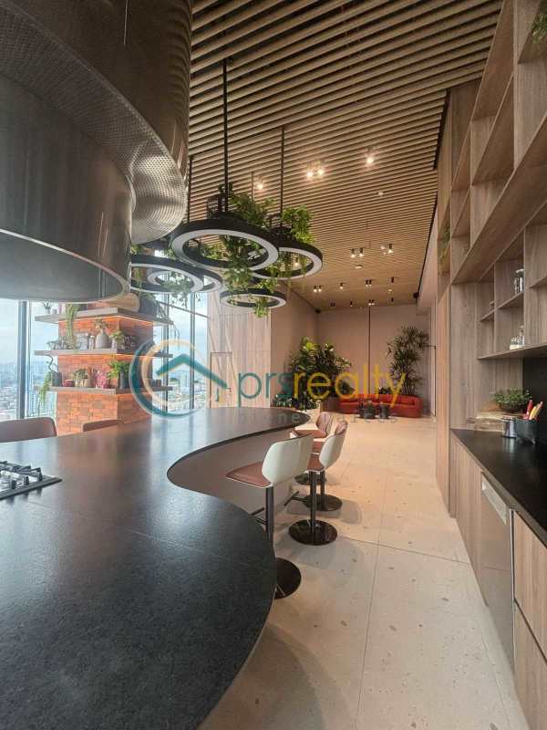 Modern kitchen with curved island, panoramic windows and dining space in PH Dovle Panama