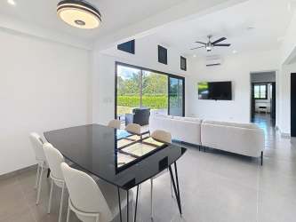 Open concept living dining area with large windows to terrace and ocean at Coco Beach Residences Panama