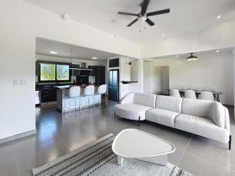 Contemporary kitchen with island breakfast bar, appliances, and ocean view at Coco Beach Private Residences Panama