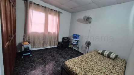 Bedroom with tile floors, ceiling fan and large window with security bars in Panama house for sale