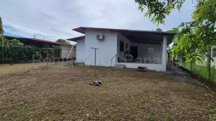 Single-story house with covered porch, large yard, and AC unit in David Chiriquí