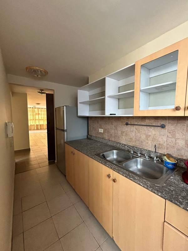 Granite tile kitchen counters, upper glass cabinets, refrigerator, in San Francisco Bay apartment Panama City