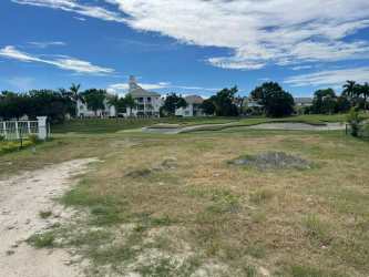 Open grass area facing golf course with nearby residential buildings at Bijao Panama