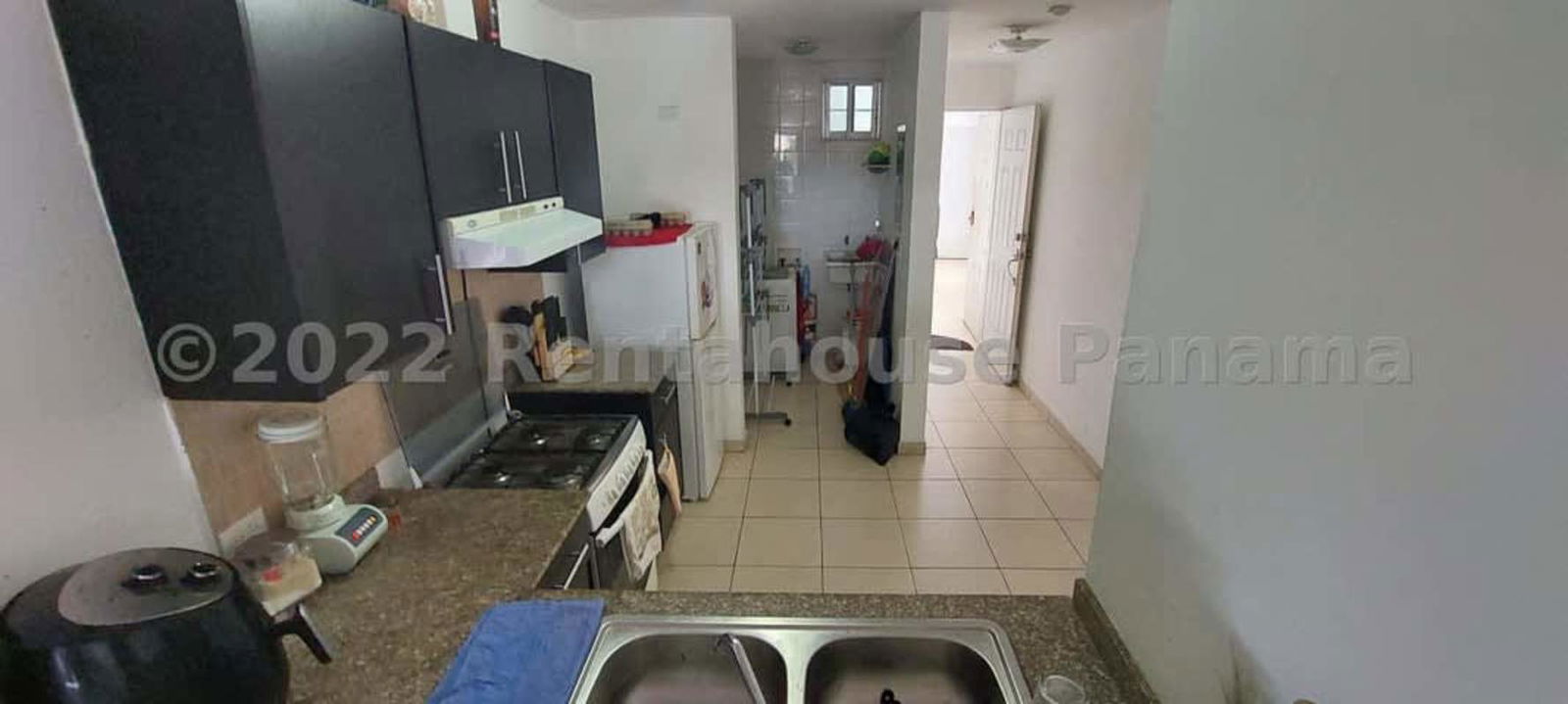 Kitchen with granite counters, black cabinets and laundry space PH Parque Lefevre Panama