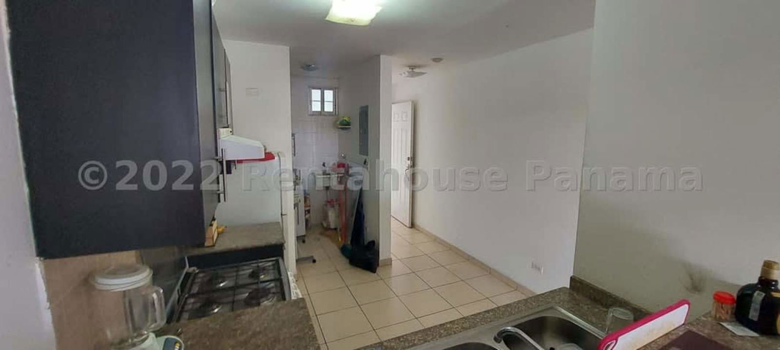 Simple bedroom with tile floors, closet, window, blue curtains PH Parque Lefevre Panama