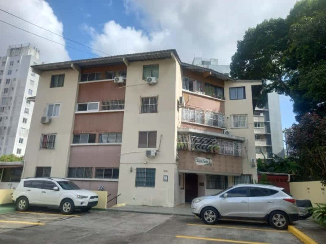 Exterior facade of mid-rise Carrasquilla apartment building with balconies and parking area