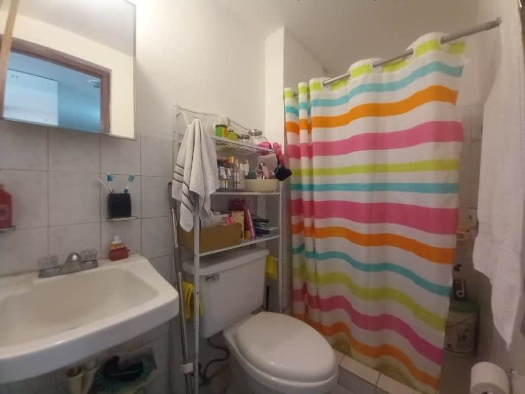 Bathroom with walk-in shower, pedestal sink, tile walls Carrasquilla apartment Panama City