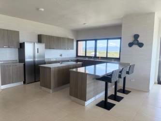 Open concept living room with floor to ceiling windows ocean views in PH Las Olas Playa Blanca