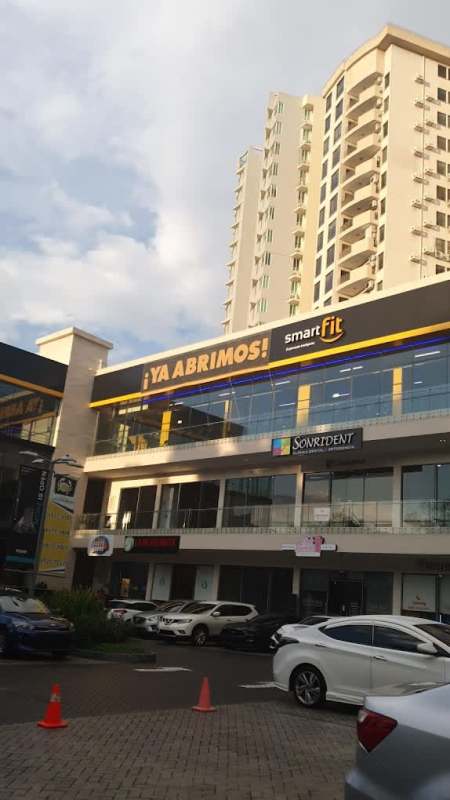 Night view of Plaza El Cangrejo with illuminated storefronts, parking lot and traffic