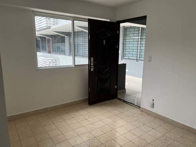 Minimalist entryway with large window, tiled floor in apartment at Via España Panama
