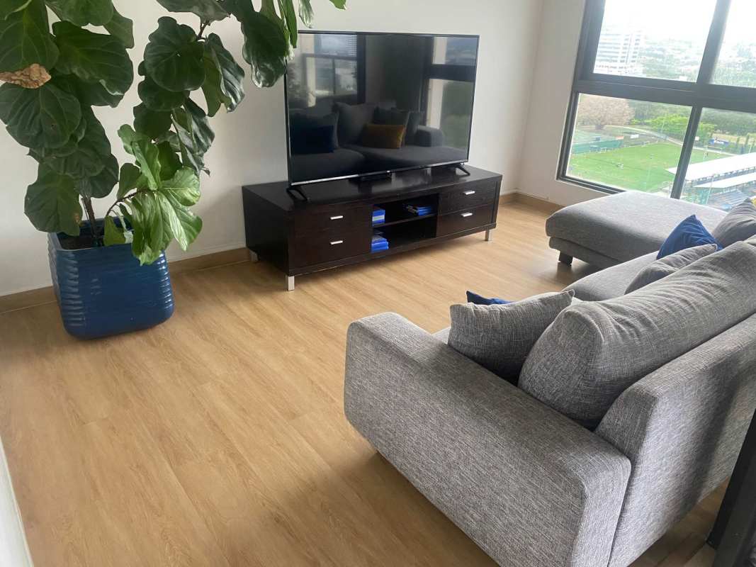 Living room with large windows gray sofa flat screen TV wooden flooring Costa del Este Panama