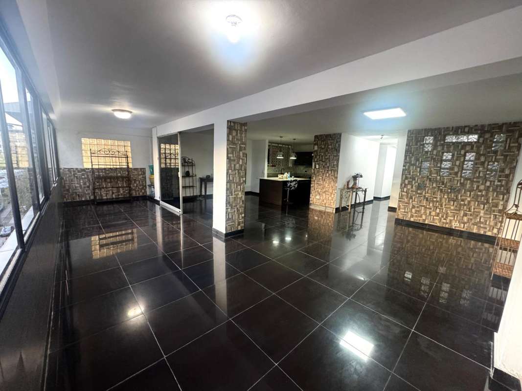 Bright living room with large windows, black tile floors in PH Altamira Panama City