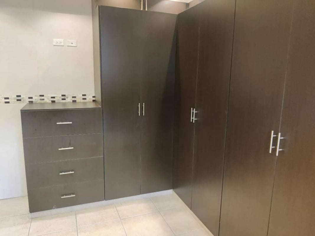 Bedroom area with built-in wardrobe and ceramic tile floors in Villa de las Fuentes Panama City