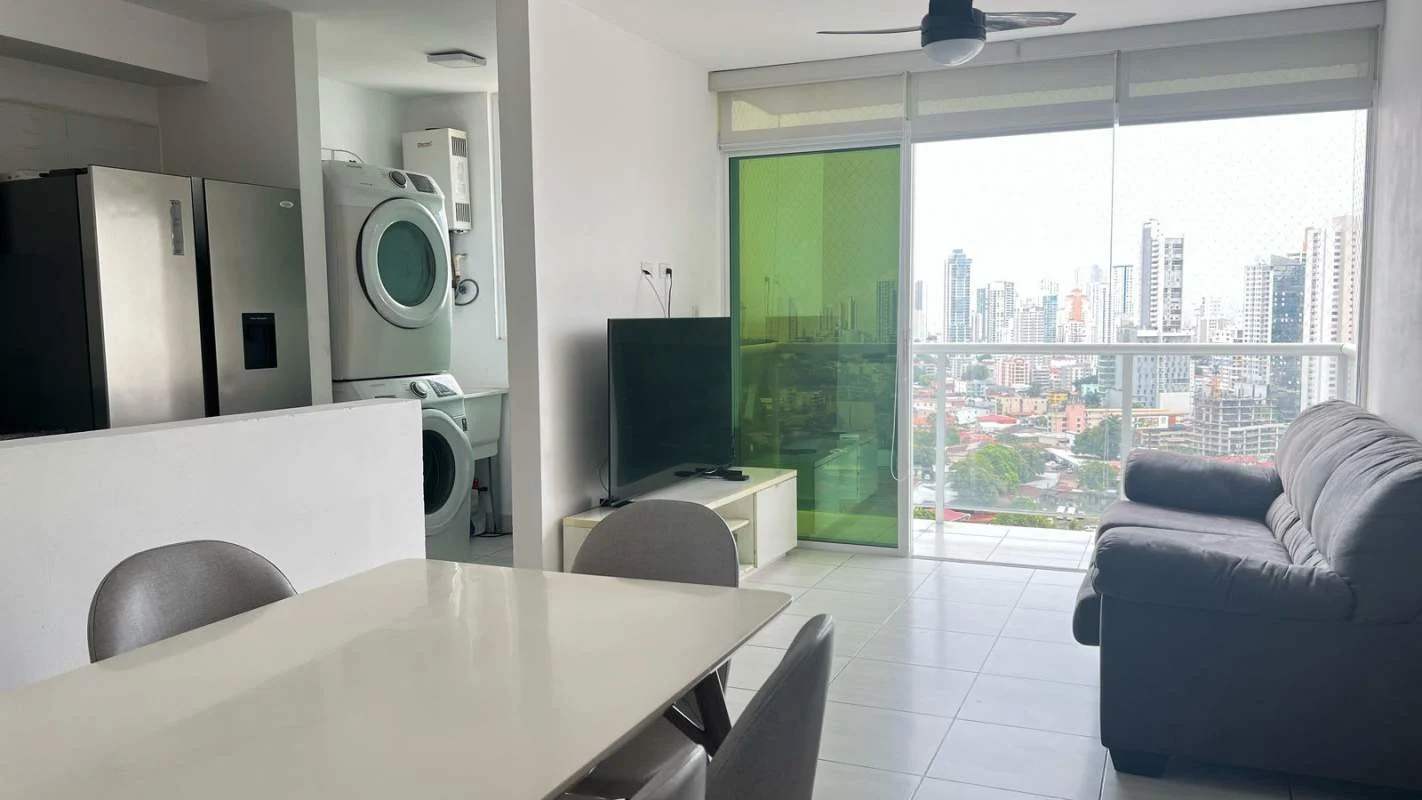 Living and dining room with balcony access, bright windows, city skyline view at PH Metropolitan Park Panama City