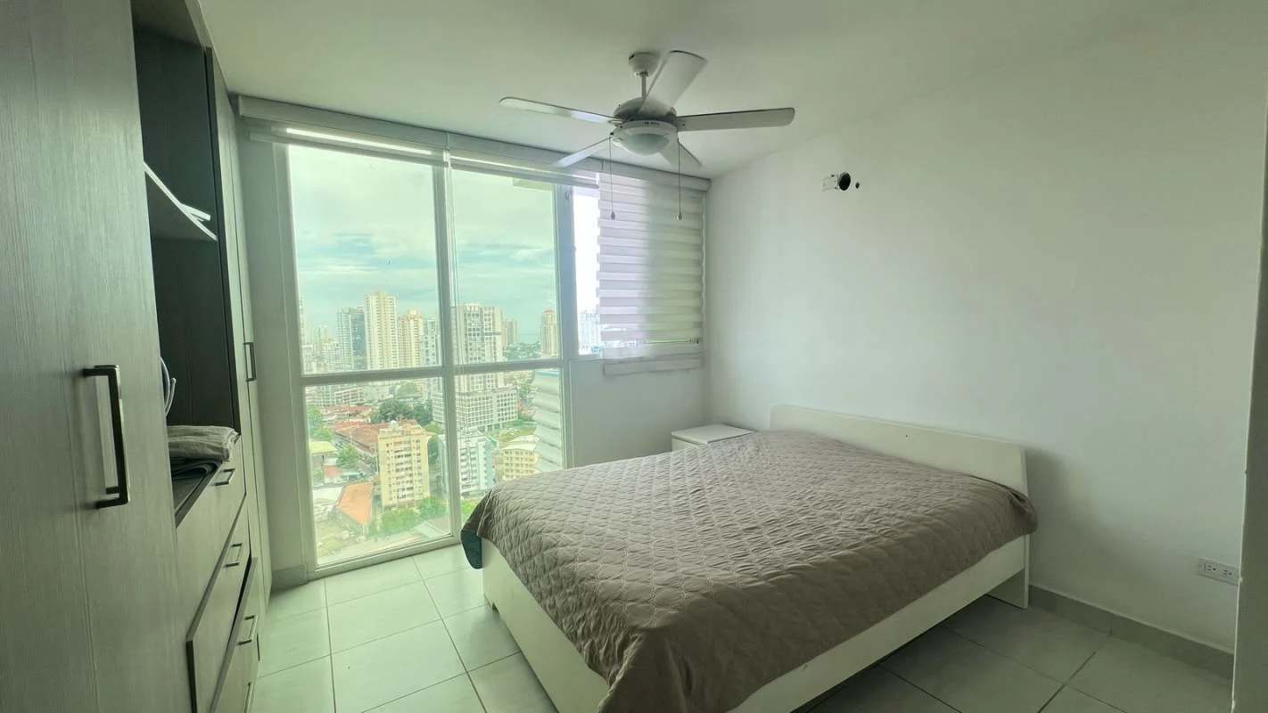 Spacious bedroom with large window and city skyline view in PH Metropolitan Park Carrasquilla Panama