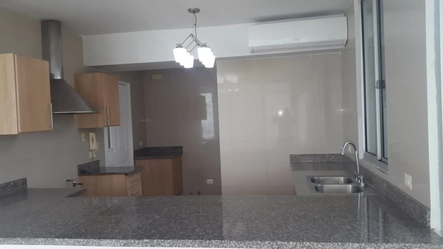 Modern kitchen with granite counters and wooden cabinets at PH Privé Panama