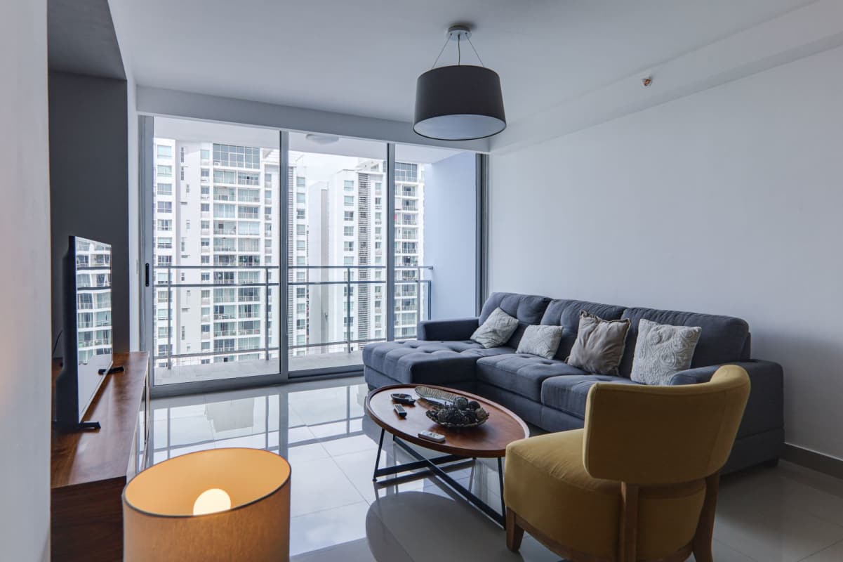 Spacious living room with glass doors to balcony city views in PH Zaphiro Panama City