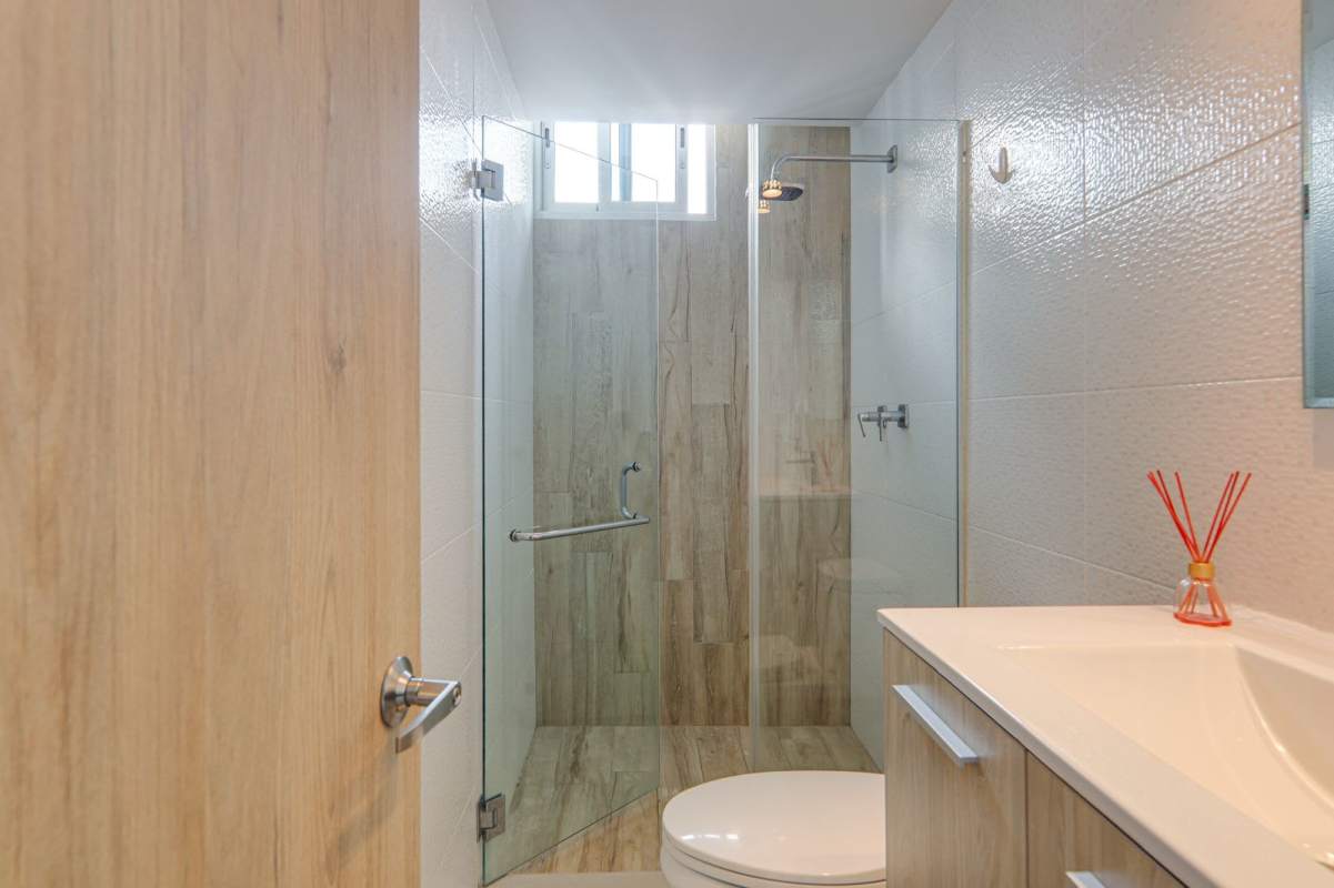 Bathroom with glass shower enclosure and wood vanity PH Zaphiro El Cangrejo Panama City