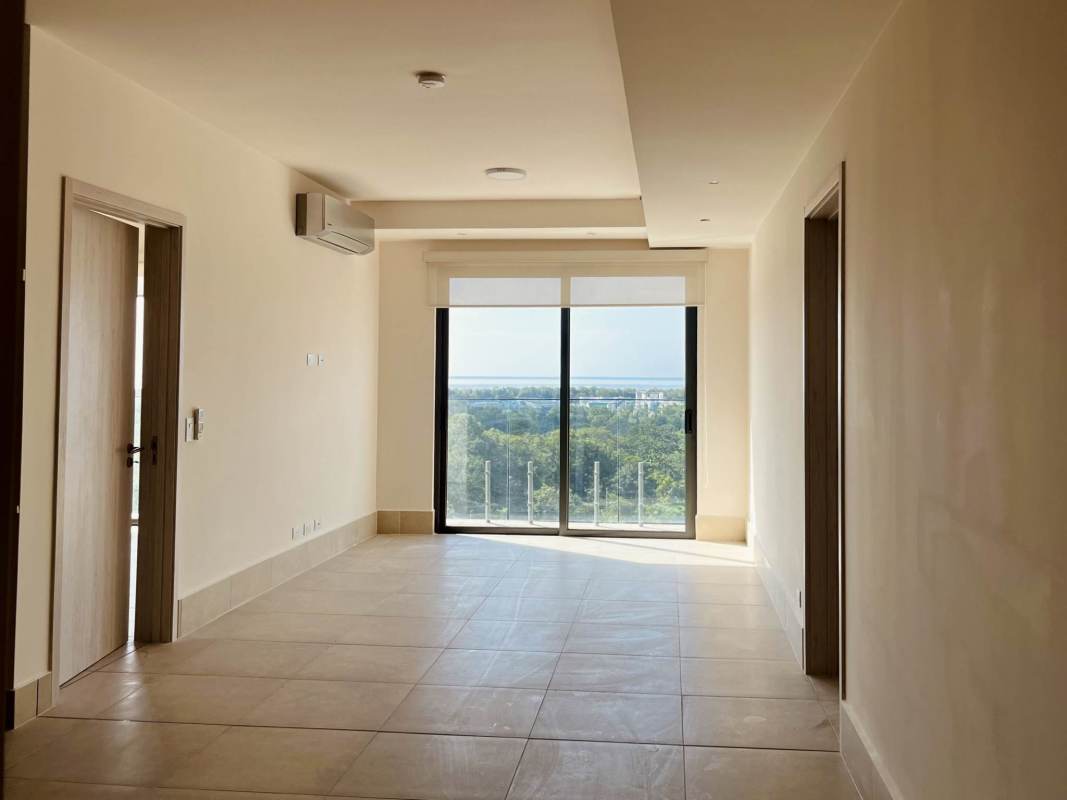 Bright living room featuring large sliding doors opening to ocean view balcony in Ocean House Santa Maria Panama