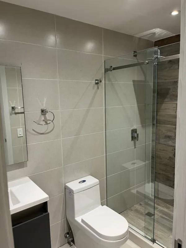 Bathroom with glass shower enclosure, wall tiles and contemporary fixtures in PH Coco Place Panama