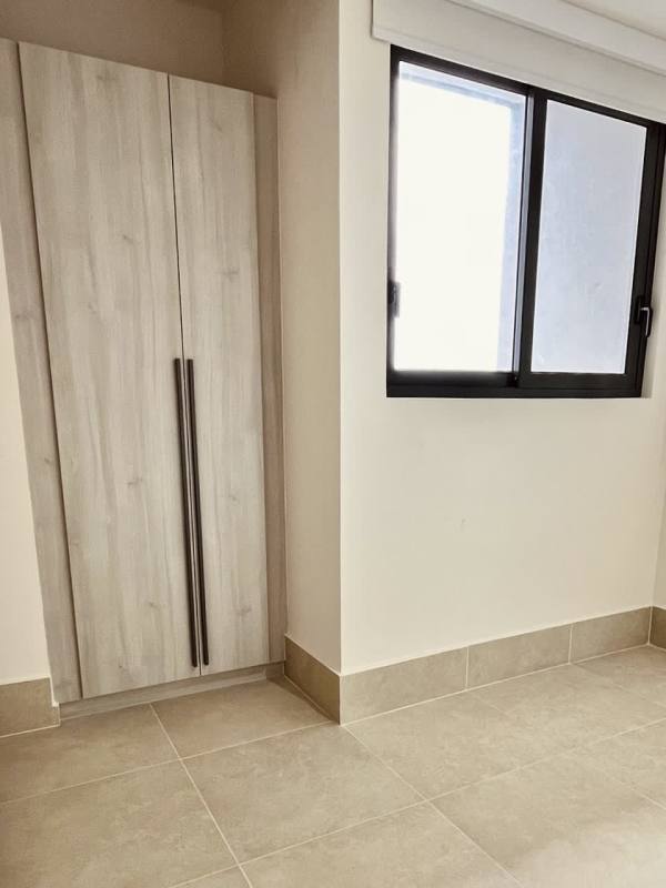 Bright bedroom with large window, roller blinds, and neutral decor at Ocean House Panama