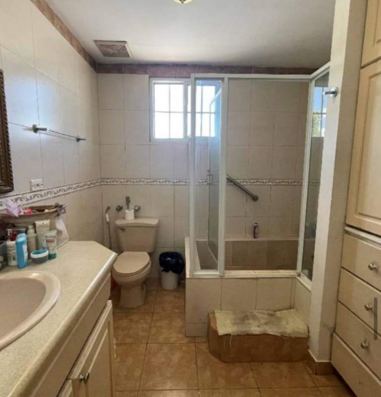 Bathroom with tiled walls, glass shower step-up tub sink vanity Villa Zaita Panama