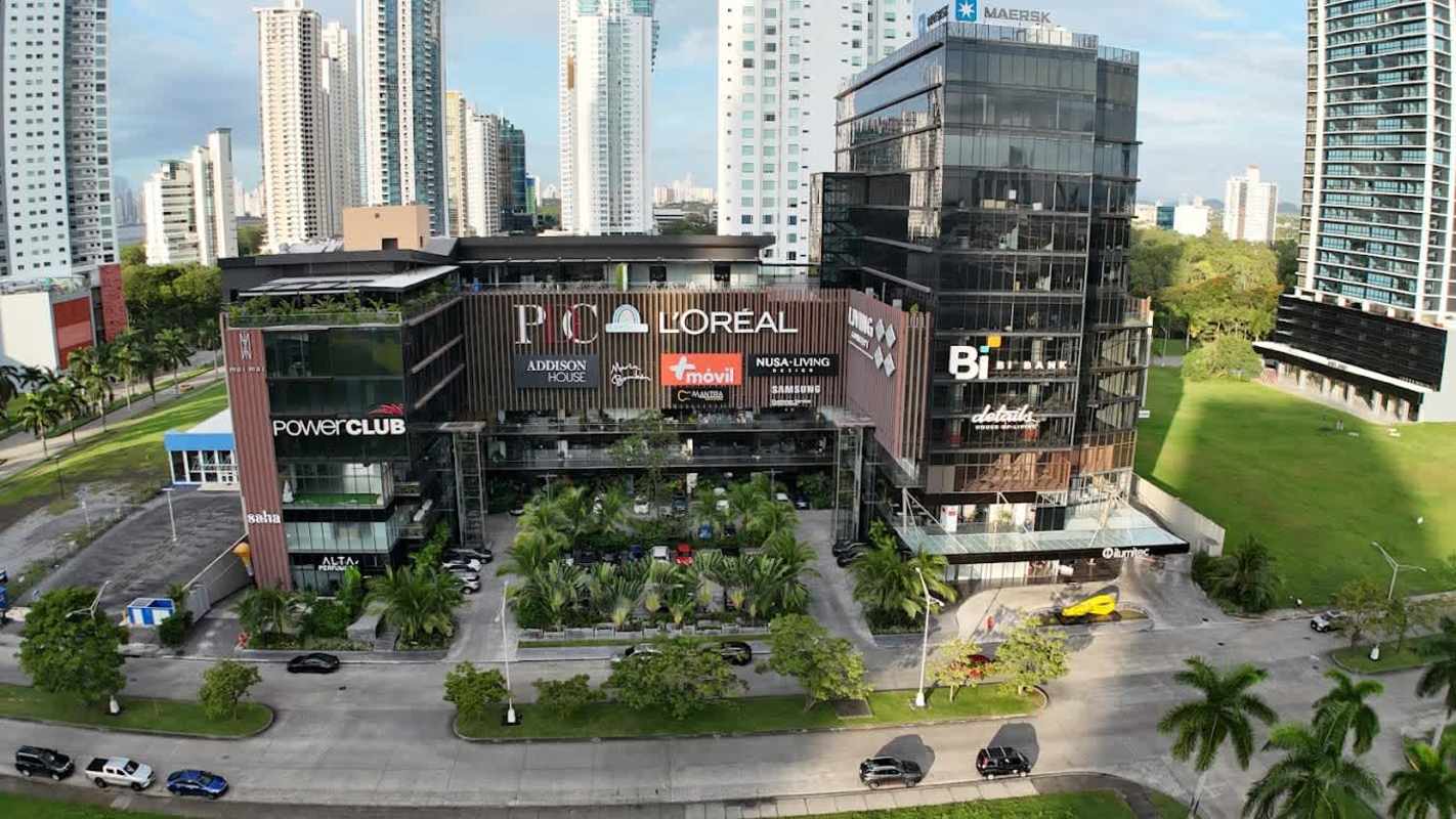 Aerial of Panama Design Center Costa del Este with glass facade, green landscaping, parking and nearby skyscrapers