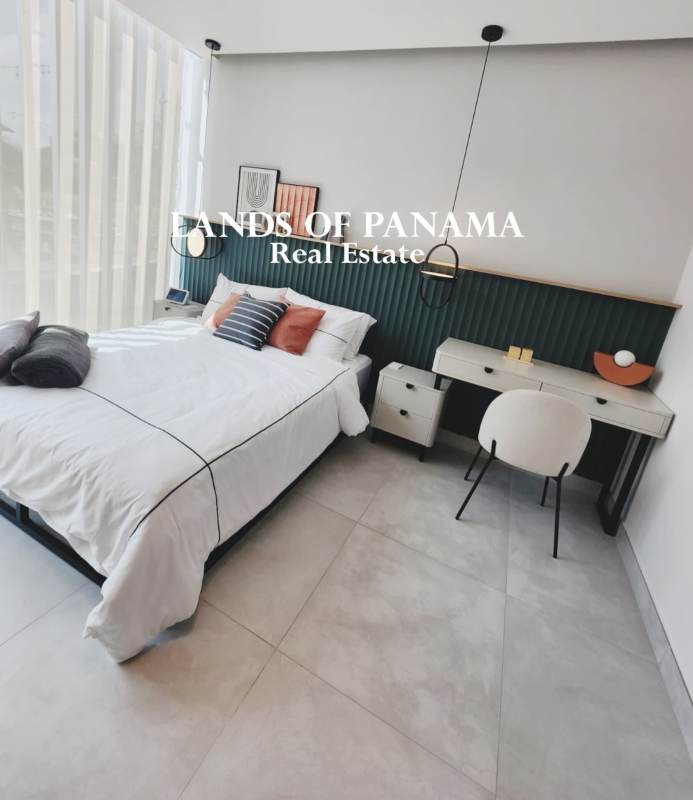 Minimalist bedroom setup with large window and city views in Costa del Este studio apartment