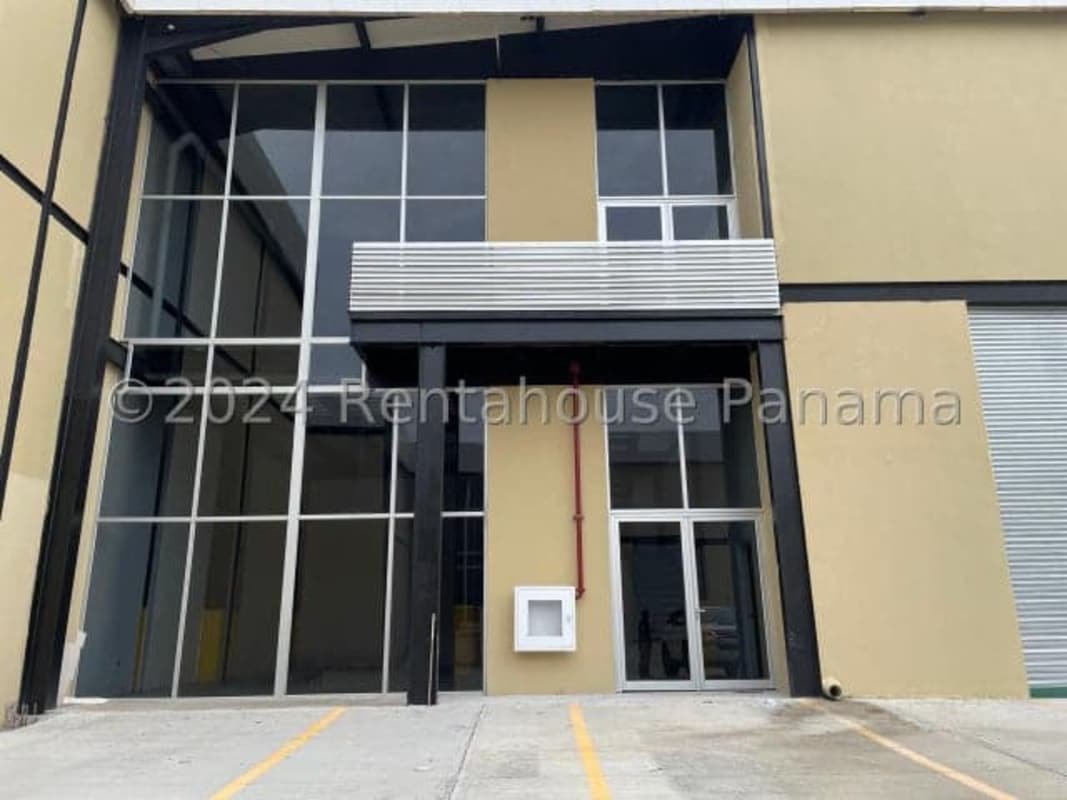 Facade of an industrial warehouse with parking area and double-height glass entrance Pacora Panama