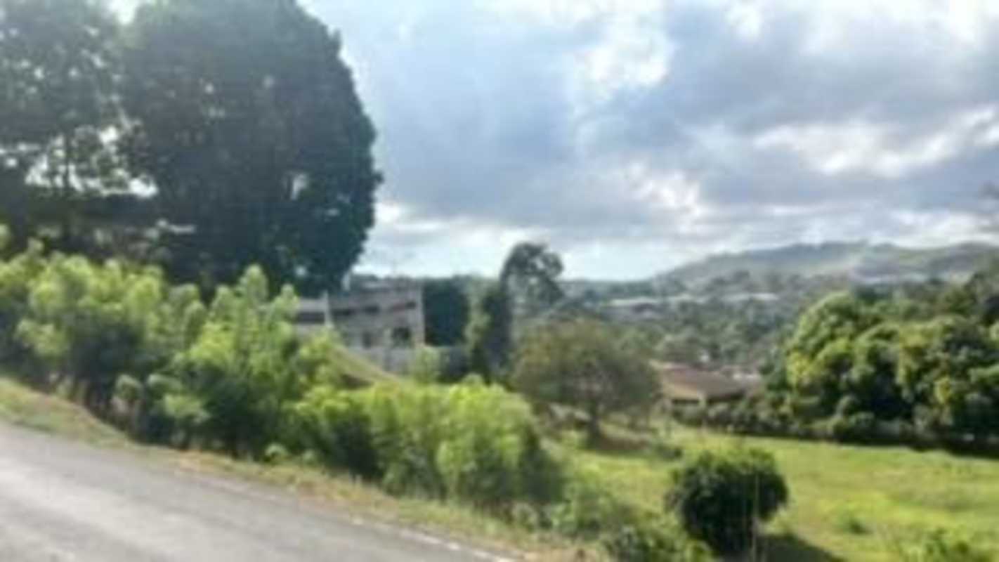 Hill with mature trees overlooking mountains and greenery in Las Cumbres Panama