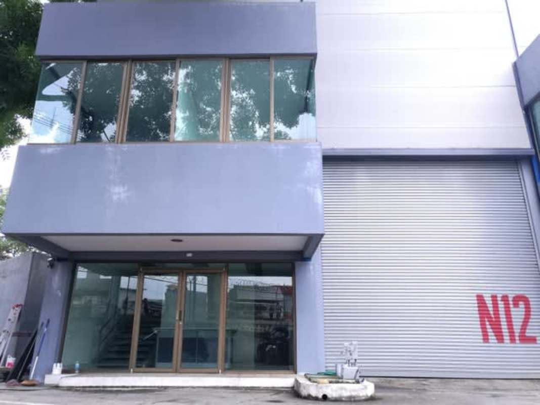 Reception area inside commercial warehouse with desk, white tiles and staircase to mezzanine in Tocumen Panama