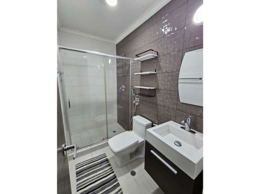 Modern bedroom with double bed, large windows, city view, AC and fan in PH Metropolitan Park Vía España Panama