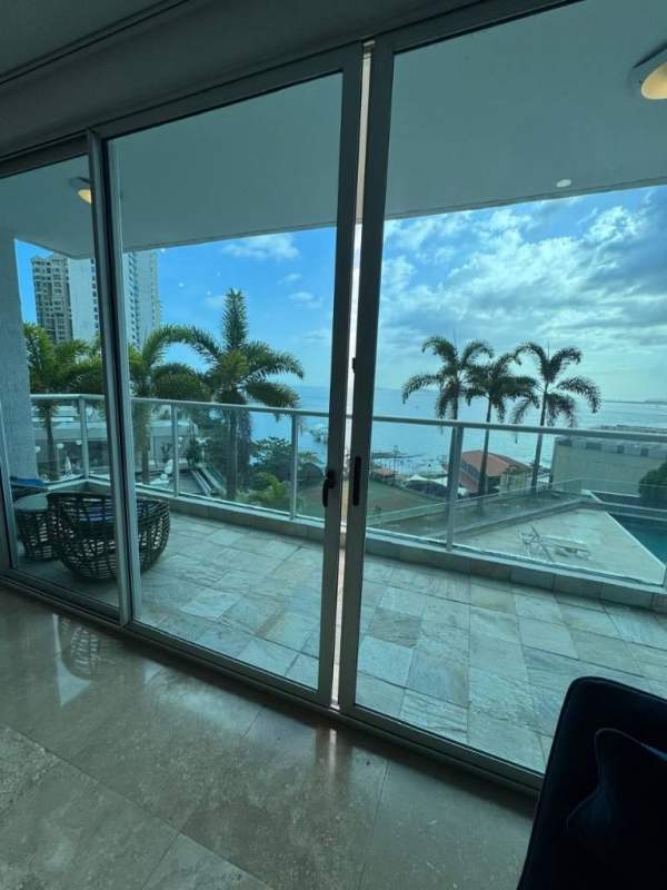 Spacious living room with glass doors to balcony and ocean view in PH Q Tower Punta Pacifica