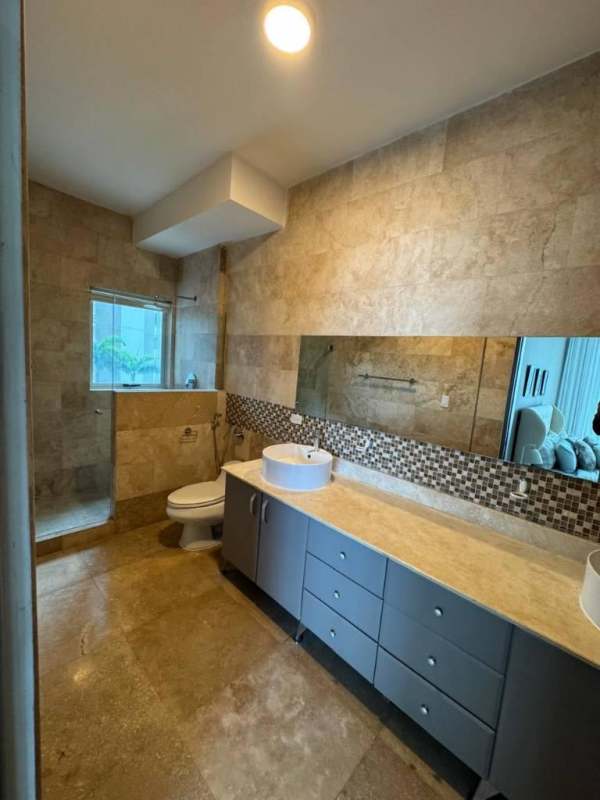 Bathroom with stone tiles, vessel sink, large mirror in PH Q Tower Punta Pacifica apartment rental