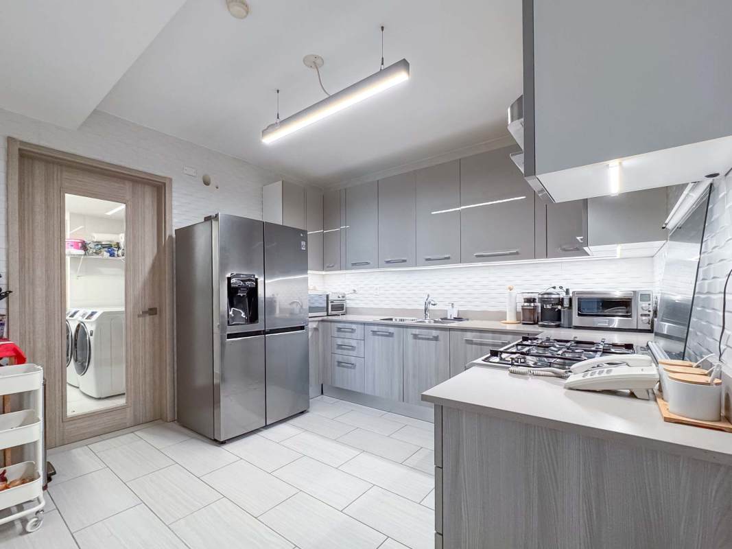 Kitchen with modern appliances and adjacent laundry area in The Towers Punta Pacifica Panama