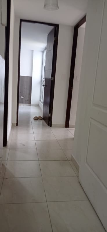 Hallway in apartment with white tile flooring and wood doors in PH McGregor