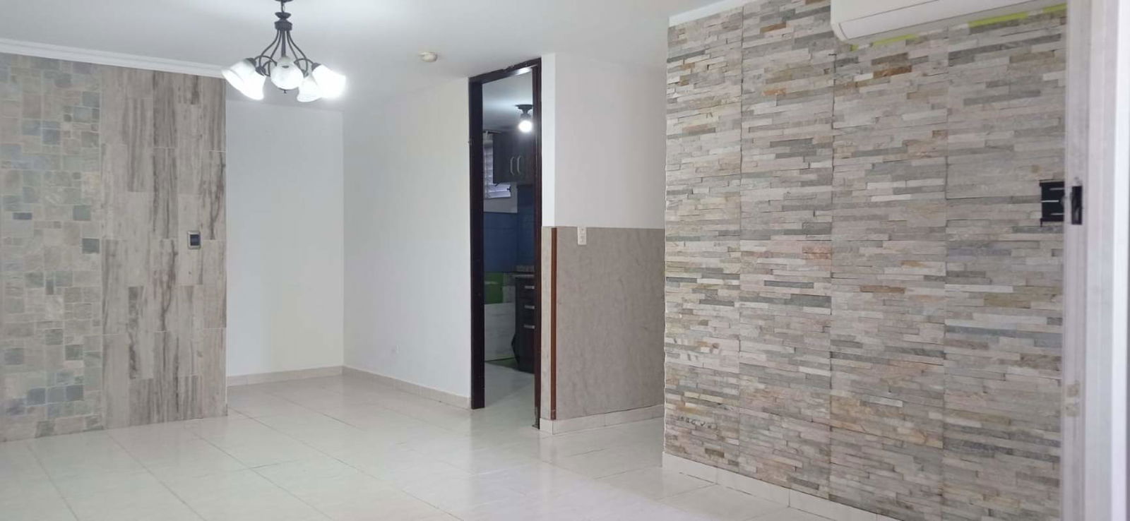 Modern living room with decorative stone wall and ceramic tile floor in PH McGregor Condado del Rey