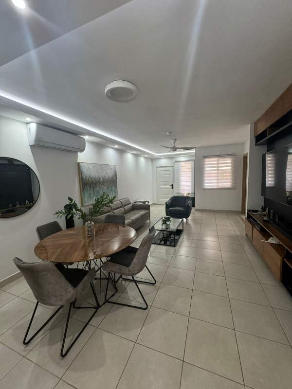 Community pool surrounded by modern villas and landscaping at PH Alpes Brisas del Golf