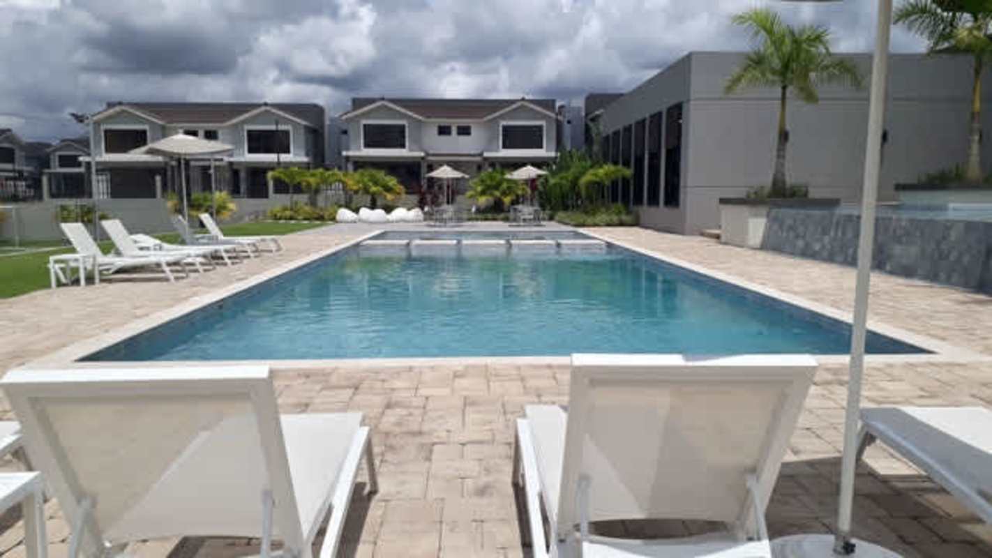 View of townhouse exteriors with garden and parking at PH Alpes Brisas del Golf