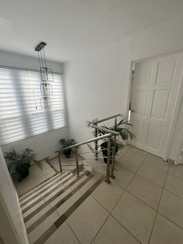 Stair landing with modern lighting, windows, metal rails at PH Alpes Panama City