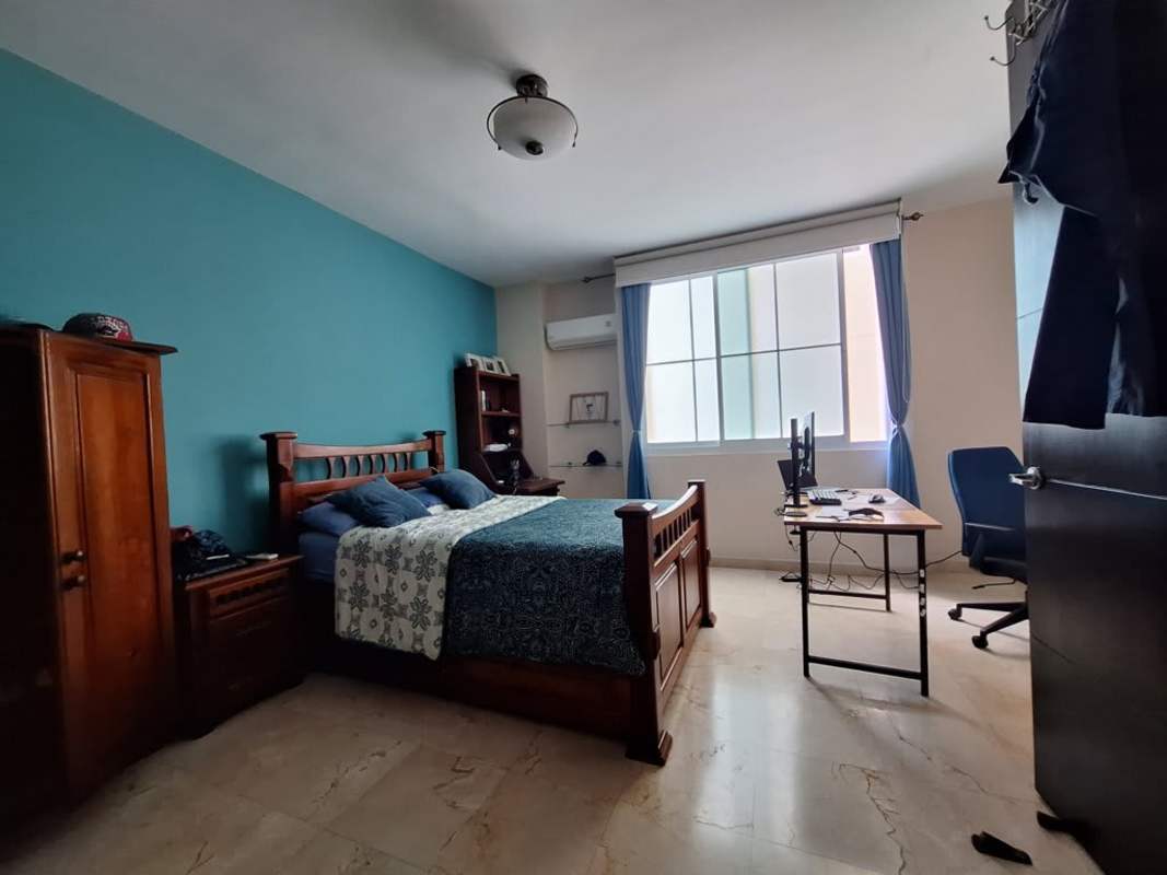 Bedroom with teal wall, workspace, ceiling light and AC Punta Pacifica Panama City