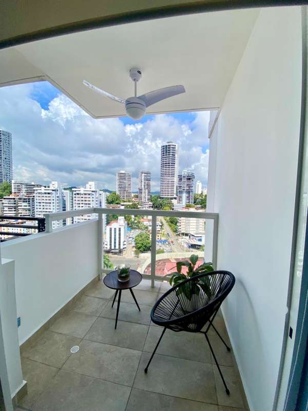 Private balcony with black outdoor chair overlooking Panama City skyline