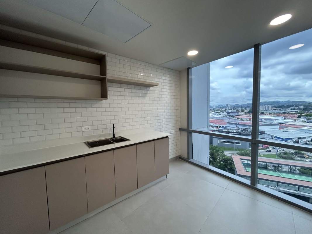 Kitchenette with cabinetry sink large window city view Financial Park Panama office