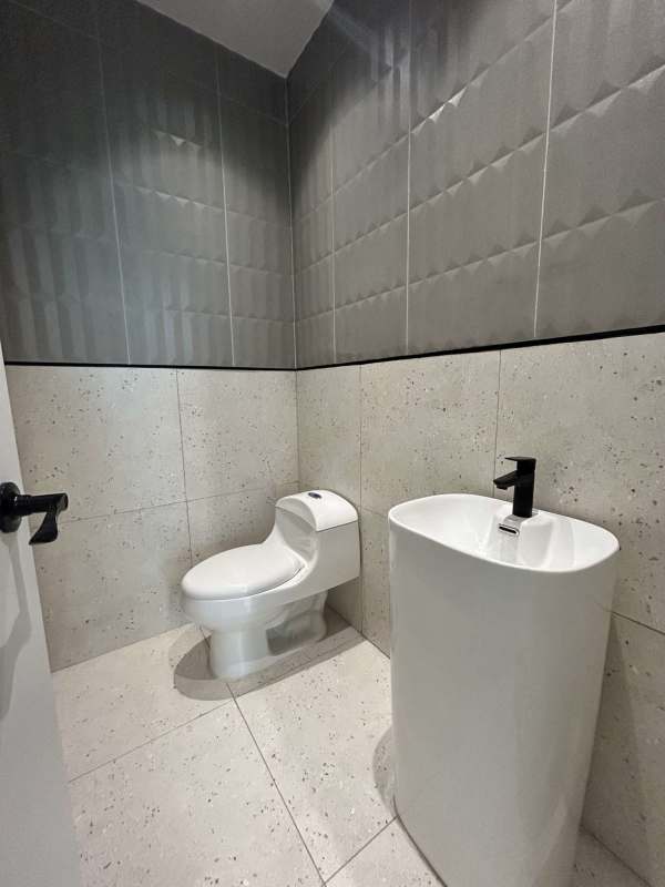 Minimalist modern bathroom gray tile white fixtures office tower Costa del Este Panama