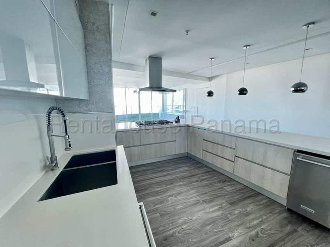 Spacious modern kitchen with island, stainless steel appliances and city view windows in PH Serrani San Francisco Panama