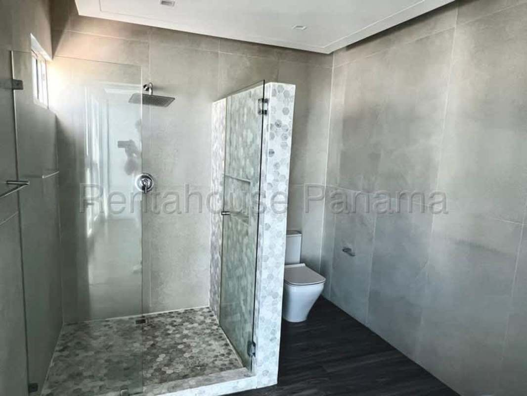 Modern bathroom with glass shower enclosure and double sinks at PH Serrani Panama City
