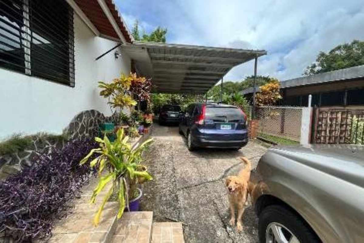 Carport with parked cars, fenced yard and mature plants, Villa Zaita house for sale