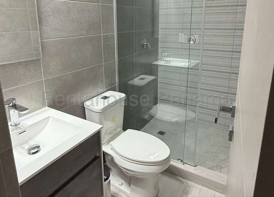 Bathroom with glass-enclosed shower, vanity sink, gray tile in PH Obarrio Sky Panama