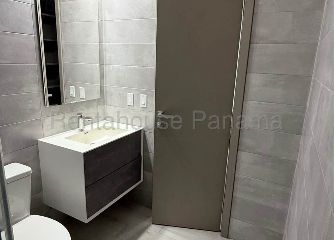Contemporary bathroom with glass shower enclosure, vanity, gray tiles PH Obarrio Sky