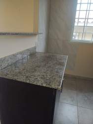 Green backyard lawn area with partial fencing rental house La Mitra Panama